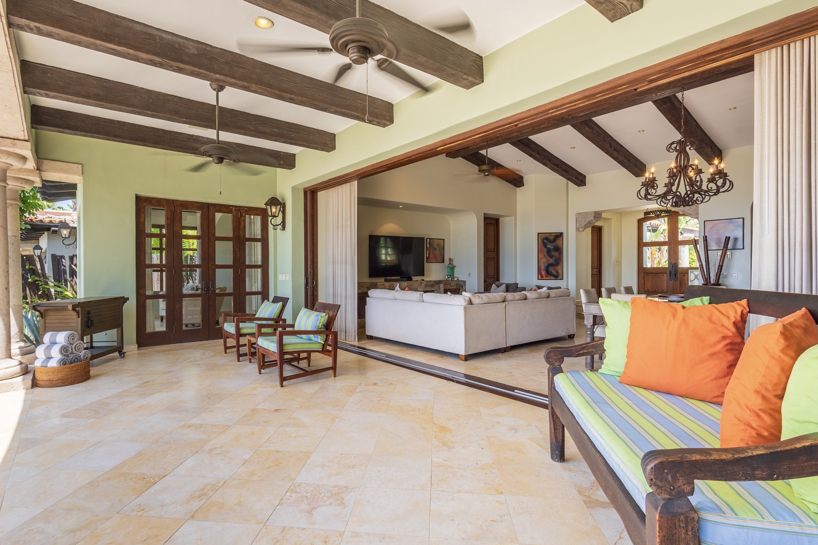 Step into your spacious open-plan haven where rustic charm meets modern comfort. Exposed wood beams frame soaring ceilings, while bright pops of color on plush seating invite you to unwind and feel right at home.