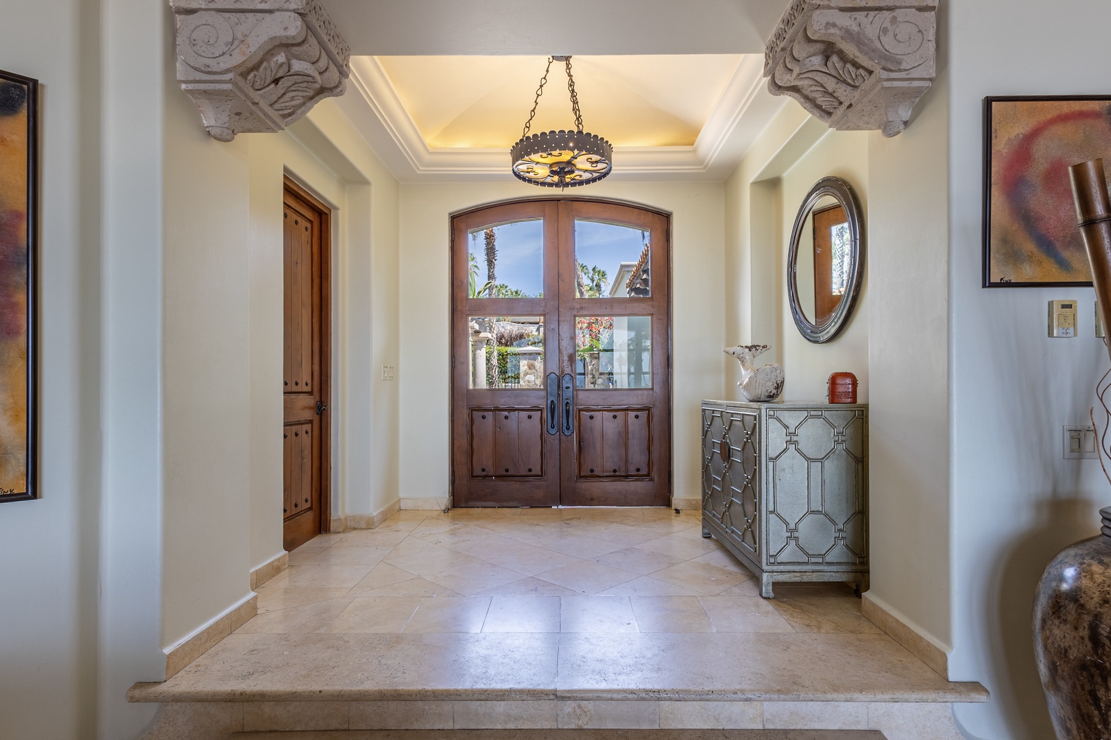 Step into elegance through your grand entrance, where ornate stone capitals and warm lighting create a welcoming first impression of your luxurious retreat.