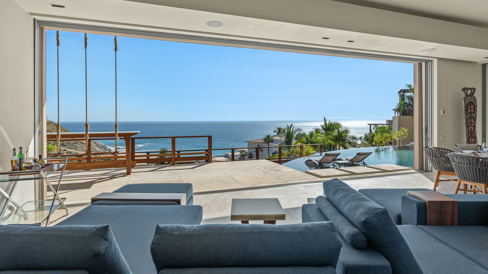 Panoramic ocean vistas stretch endlessly from this stunning open-air living space, where sleek modern furnishings frame your private infinity pool and terrace, creating an unforgettable tropical escape.