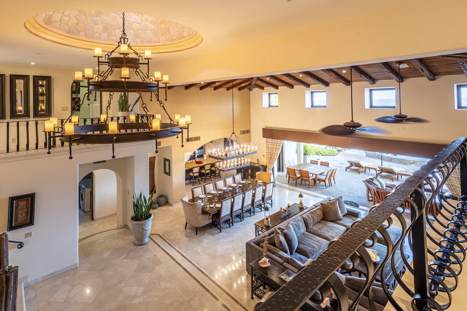 Your grand vacation villa welcomes you with soaring ceilings, warm stone floors, and elegant chandeliers. The open-concept design flows effortlessly from cozy lounging to indoor-outdoor dining, perfect for gathering with loved ones.