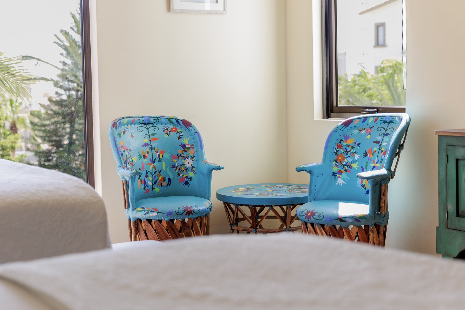 Your private sitting nook features handcrafted chairs with vibrant floral upholstery, bathed in natural light and framed by serene garden views—perfect for morning coffee or quiet reflection.