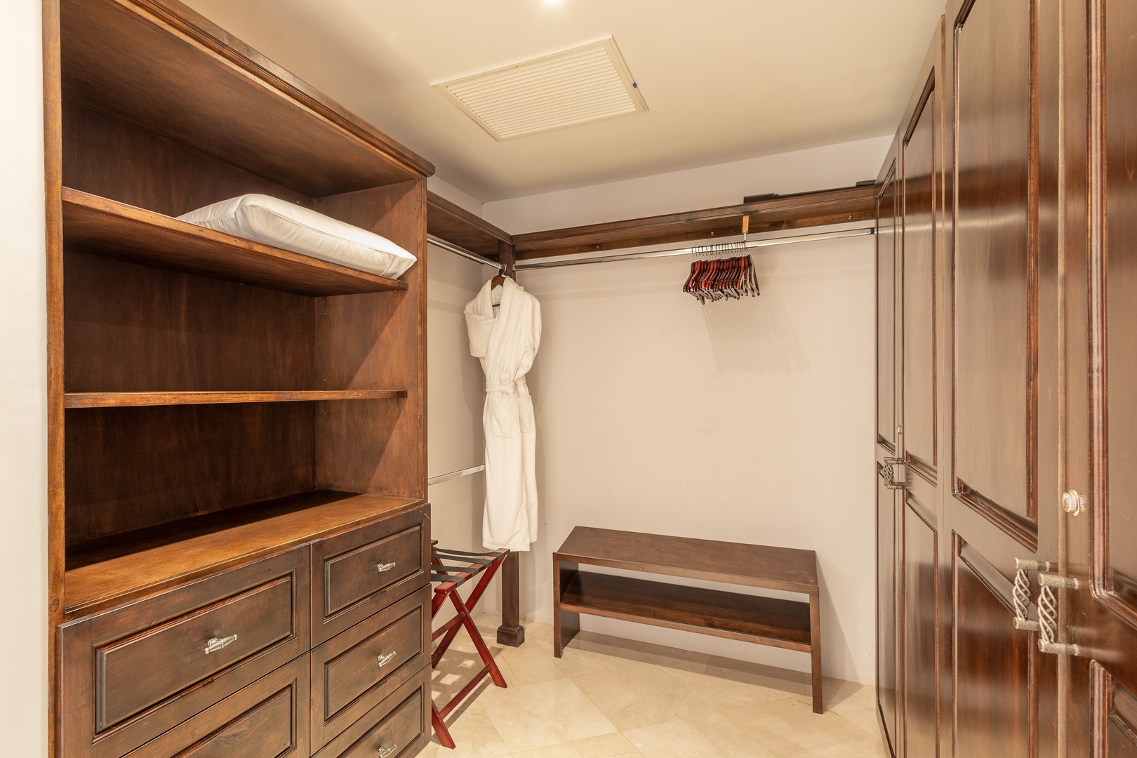Your own private walk-in closet awaits, with custom wood shelving, drawers, and hanging space to keep everything organized and within reach throughout your stay.