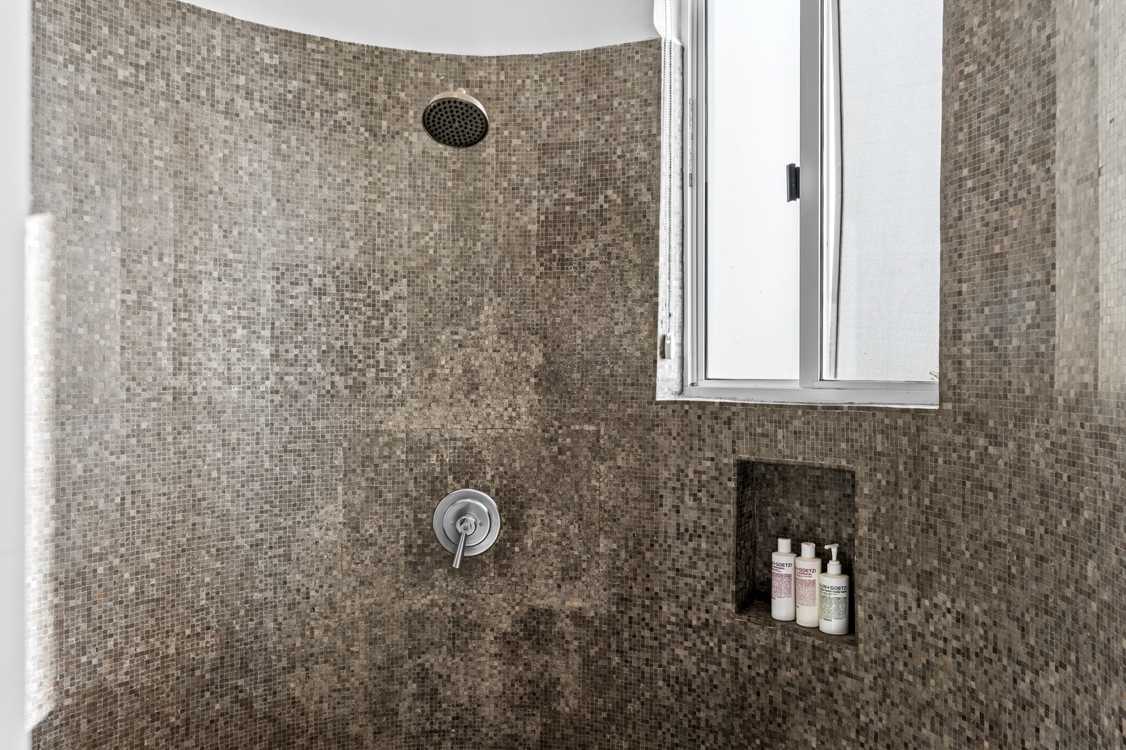 Step into your spa-like mosaic shower with rainfall head and convenient built-in niche for your essentials.