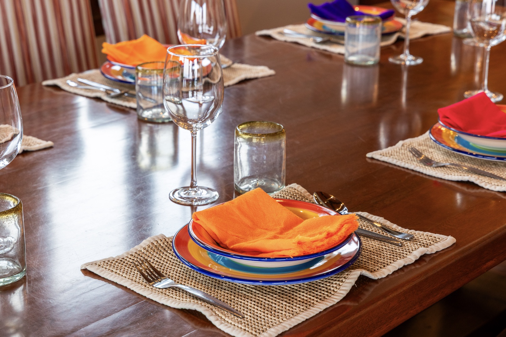 Gather around this inviting dining table, set with vibrant hand-painted plates and colorful linens, ready for your group meals and memorable evenings together.