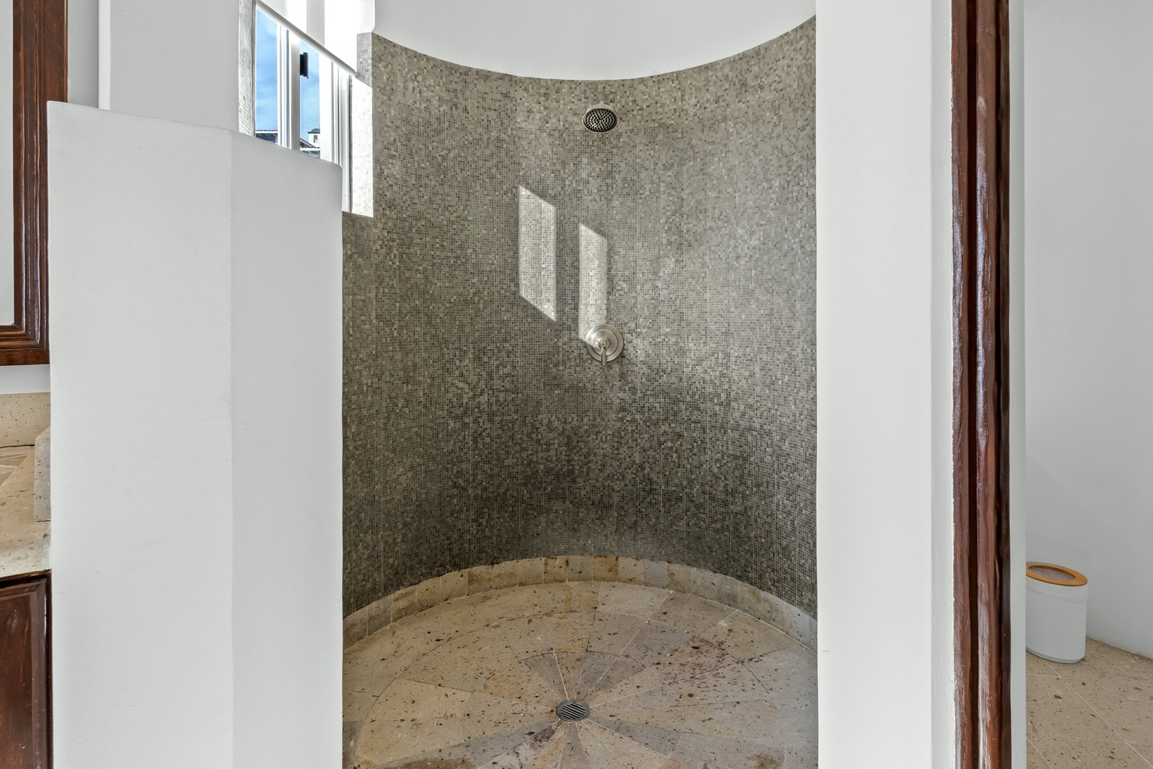 Step into your private spa-like shower with stunning mosaic tile walls and rainfall showerhead for pure relaxation.