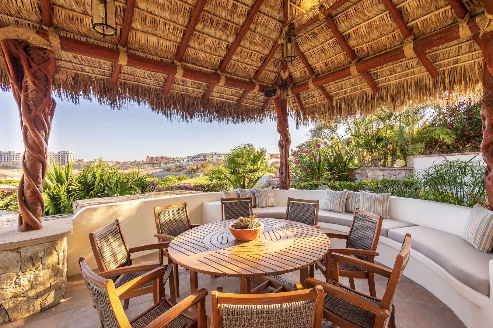 Gather around this inviting outdoor dining space, where a thatched palapa roof provides cool shade as you enjoy meals with lush tropical gardens and scenic views all around.