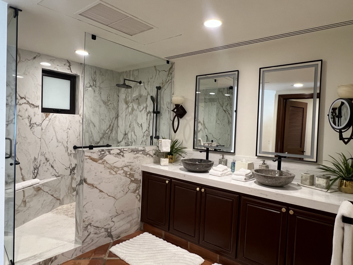 Luxurious marble bathroom with dual vessel sinks, rainfall shower, and elegant fixtures—your private spa retreat awaits.