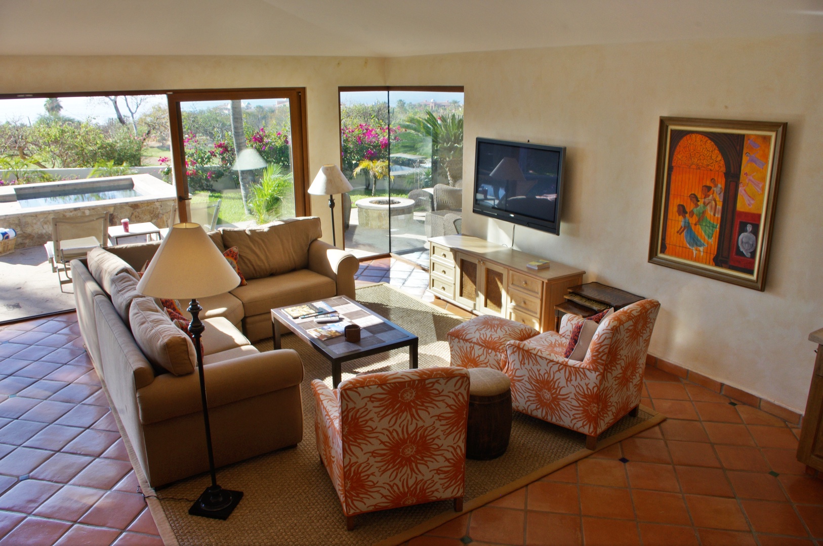 Sink into plush seating with vibrant artwork and natural light streaming through garden views. Your entertainment awaits with a mounted TV and direct access to your private outdoor terrace.