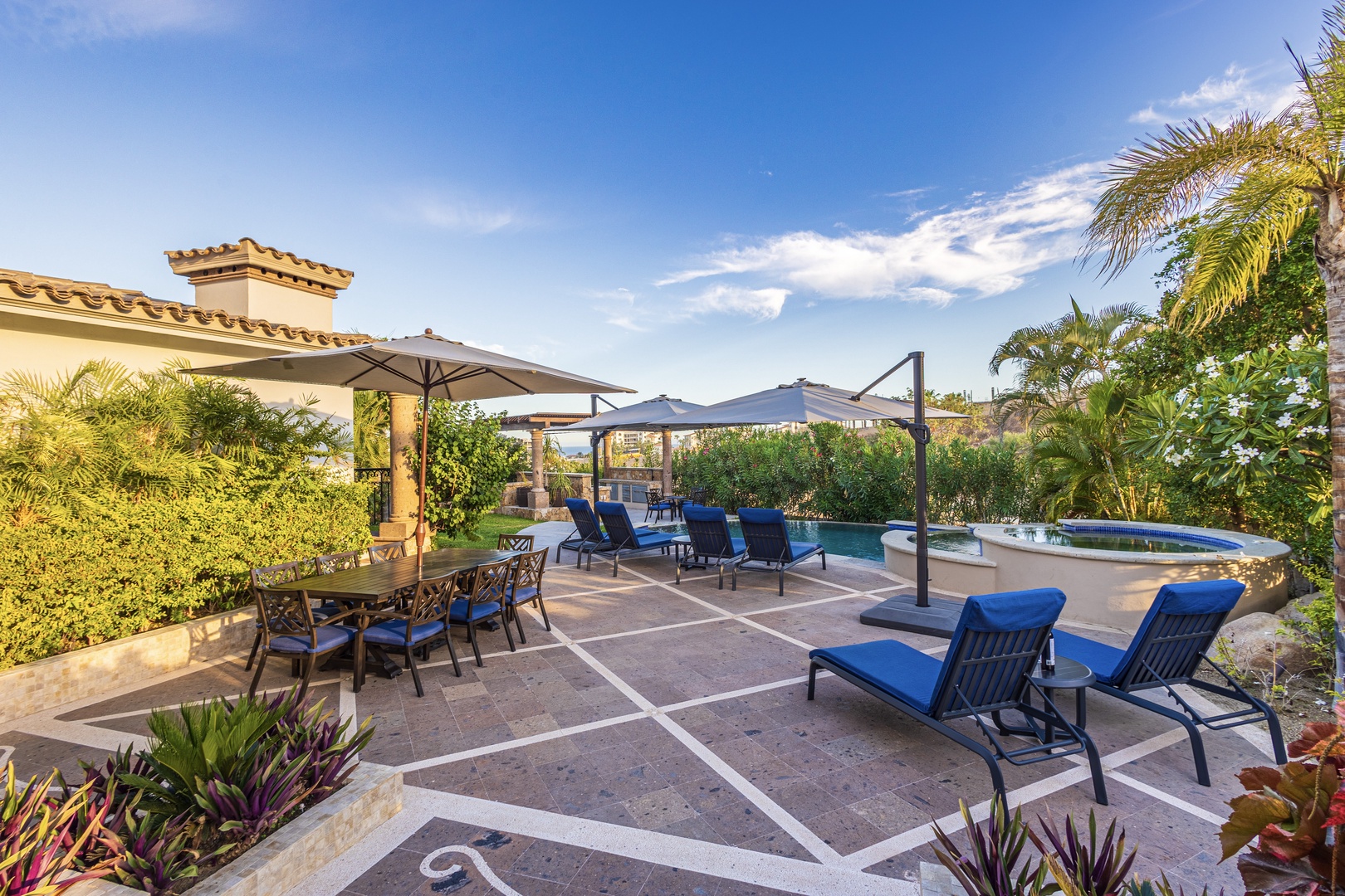 Picture yourself lounging poolside under swaying palms, where plush blue chaises and shaded dining await. Your private oasis features sparkling waters and lush tropical gardens—pure vacation bliss.