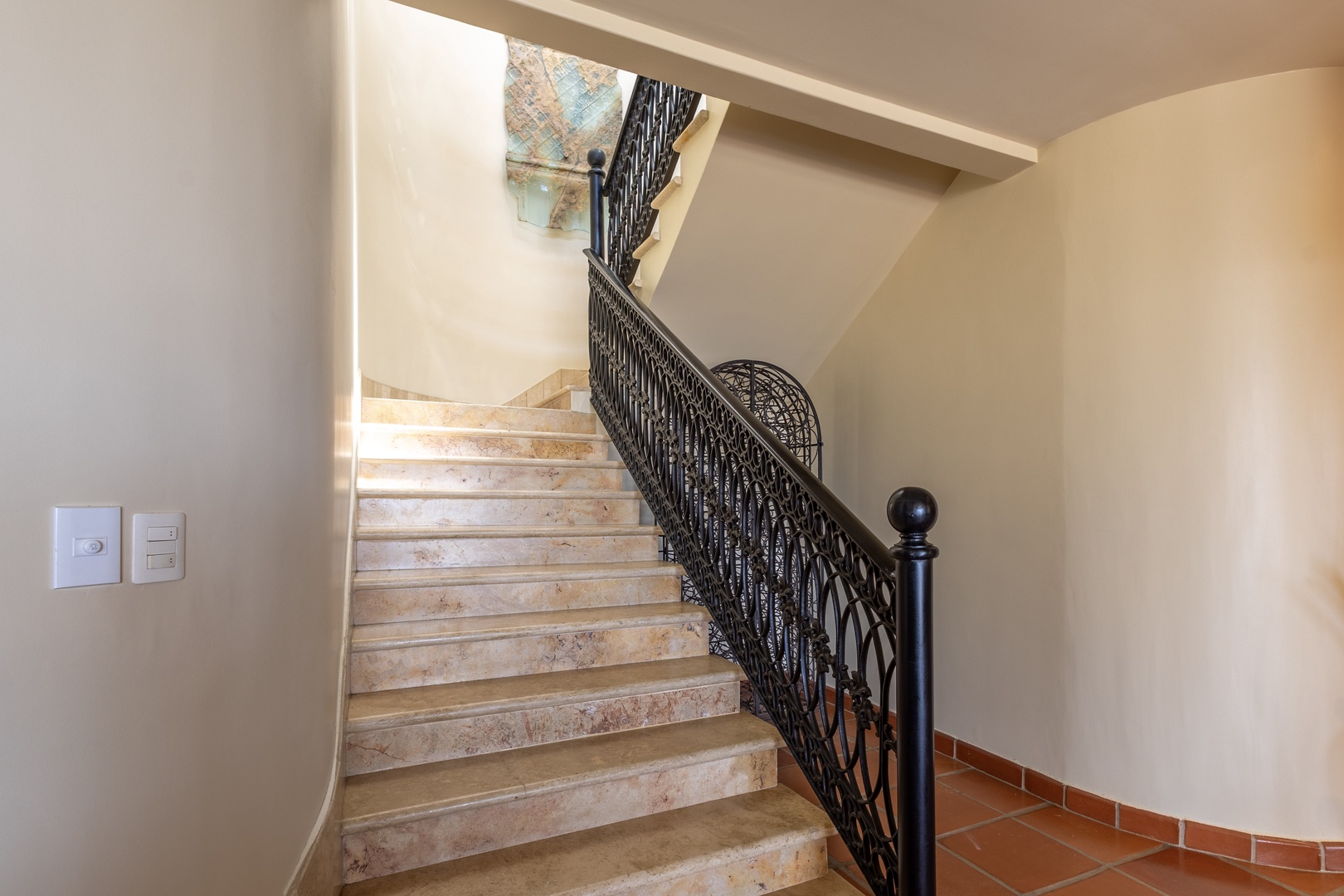 The elegant marble staircase with decorative wrought-iron railings leads you between floors, combining classic architectural charm with easy access to your multi-level living space.