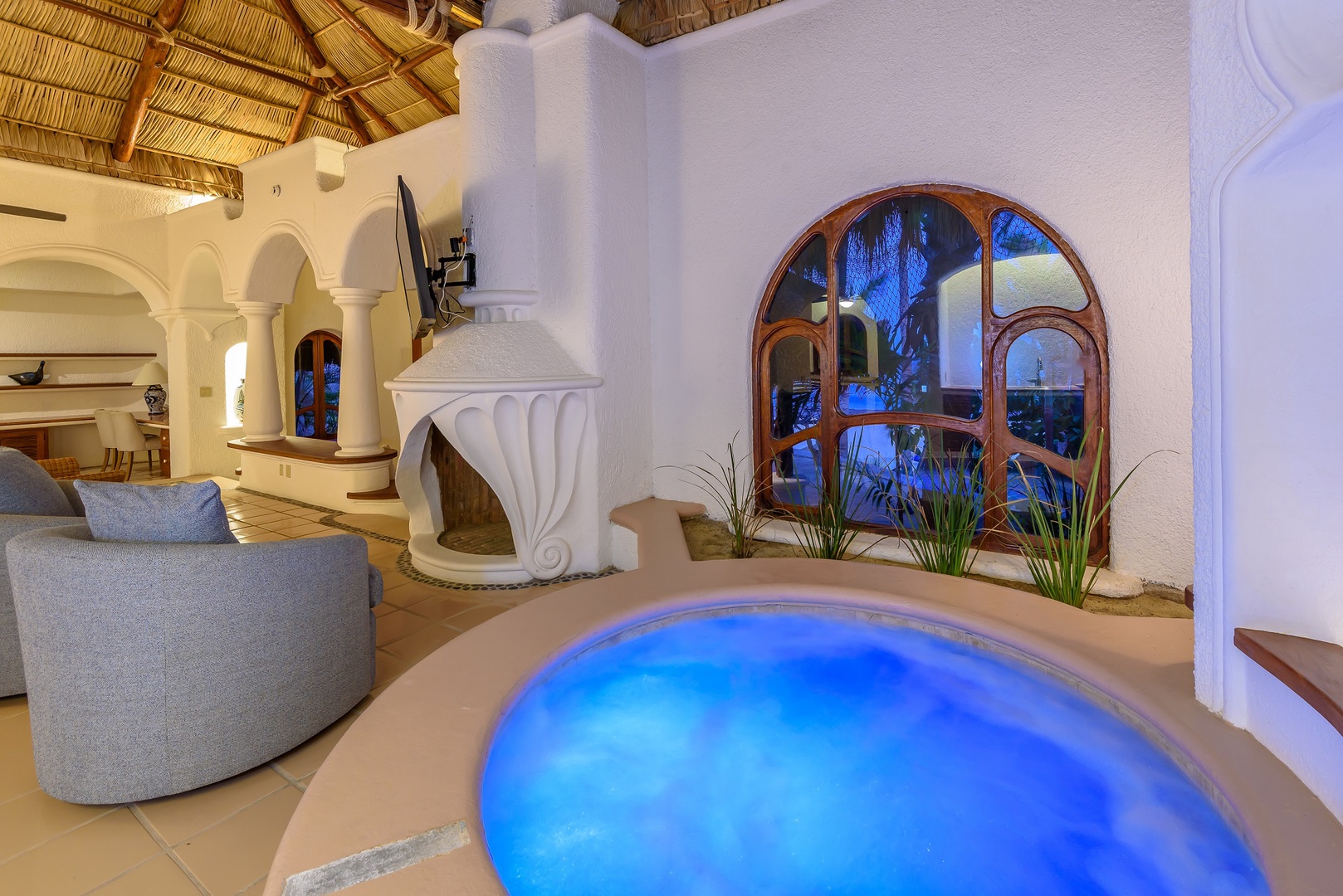 Unwind in your private hot tub beneath a soaring palapa ceiling, where architectural elegance meets pure relaxation. The glowing water and tropical ambiance create your perfect escape.