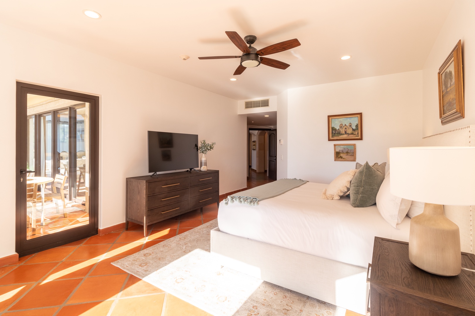 Sink into crisp linens and drift off under gentle ceiling fan breezes. Your serene retreat offers a flat-screen TV, stylish furnishings, and direct patio access for morning coffee in the sunshine.