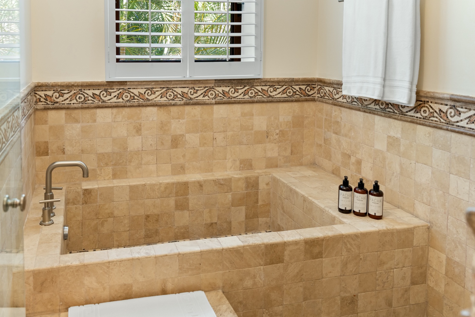 Sink into luxury in your travertine soaking tub, complete with premium bath products for the ultimate relaxation experience.