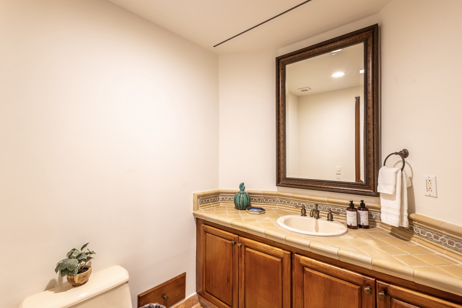 Your spacious bathroom features elegant tile countertops, warm wood cabinetry, and thoughtful touches that make your daily routine feel luxurious.