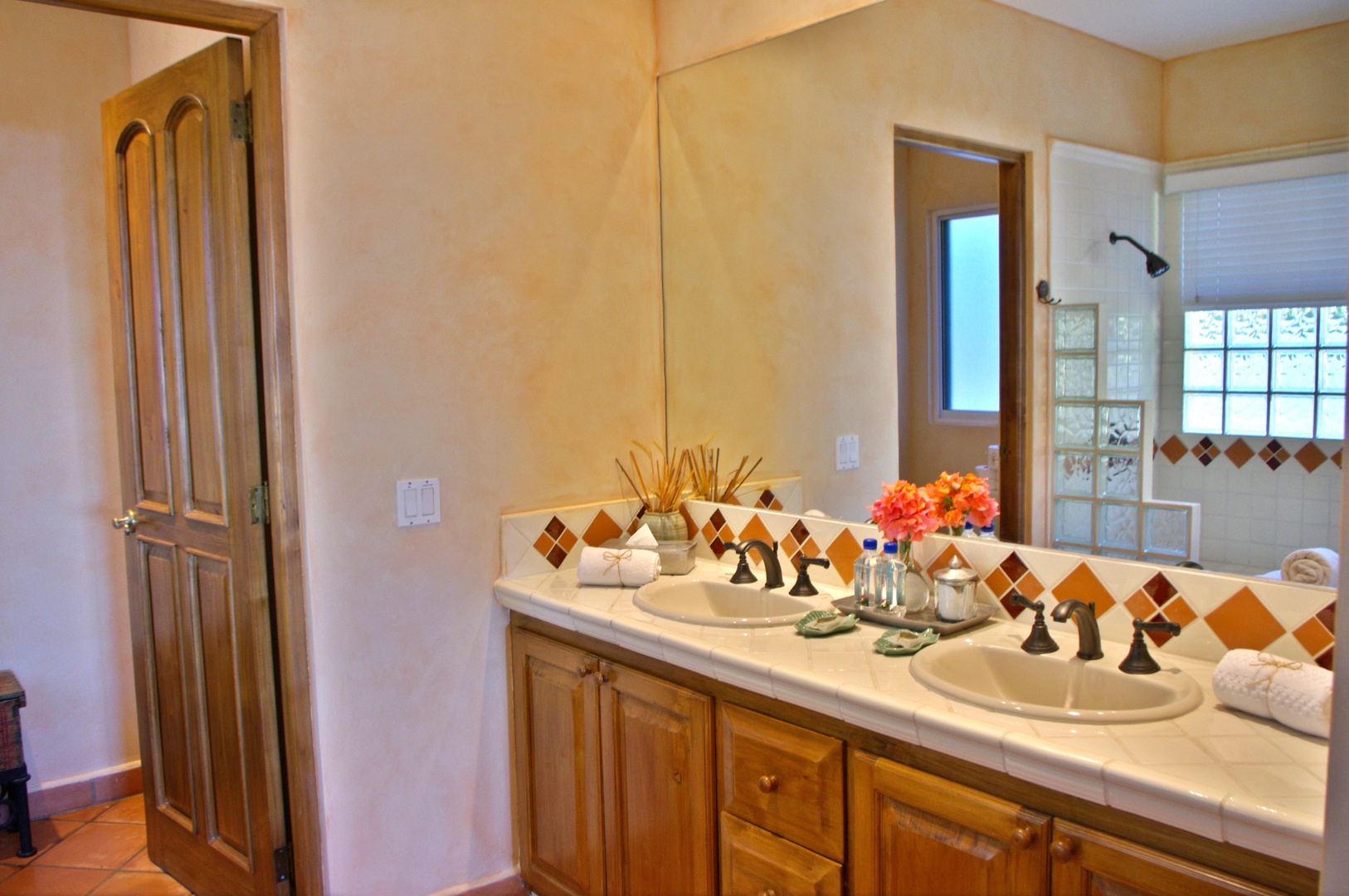 Freshen up in your spacious bathroom with dual sinks, warm tile accents, and natural light—everything you need to start your day refreshed.