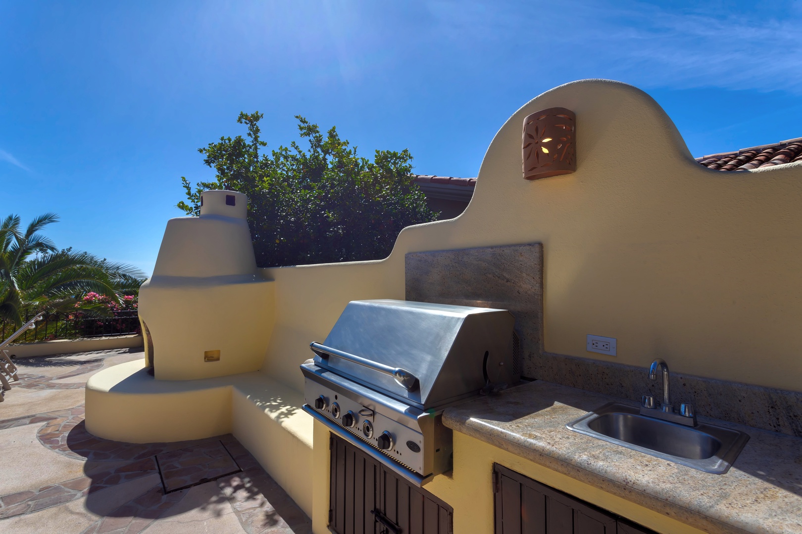Fire up the grill in your private outdoor kitchen, complete with prep sink and counter space under endless blue skies.