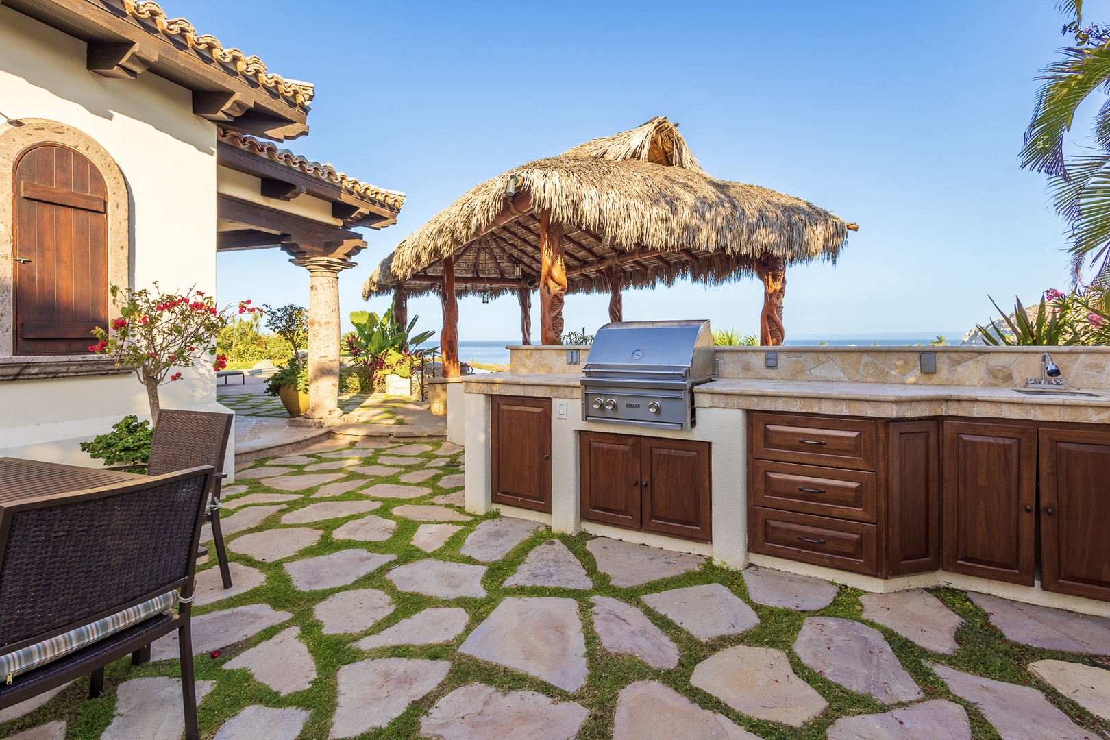 An outdoor kitchen with ocean views awaits your culinary adventures, complete with a grill under a palapa shade. Imagine grilling your catch of the day on warm stone pavers as sea breezes drift in.