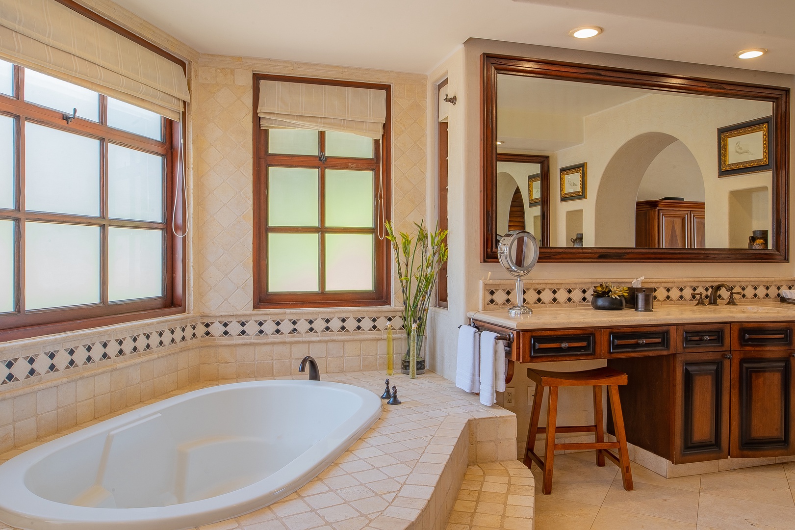 Indulge in your luxurious soaking tub while natural light streams through elegant windows, creating the perfect spa-like retreat.