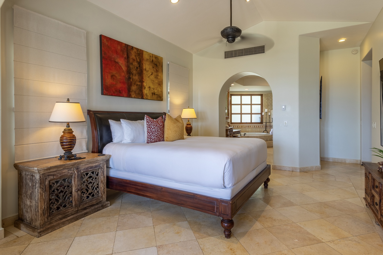 Unwind in your elegant bedroom featuring crisp white linens, warm ambient lighting, and sophisticated Mexican-inspired décor that creates the perfect sanctuary.