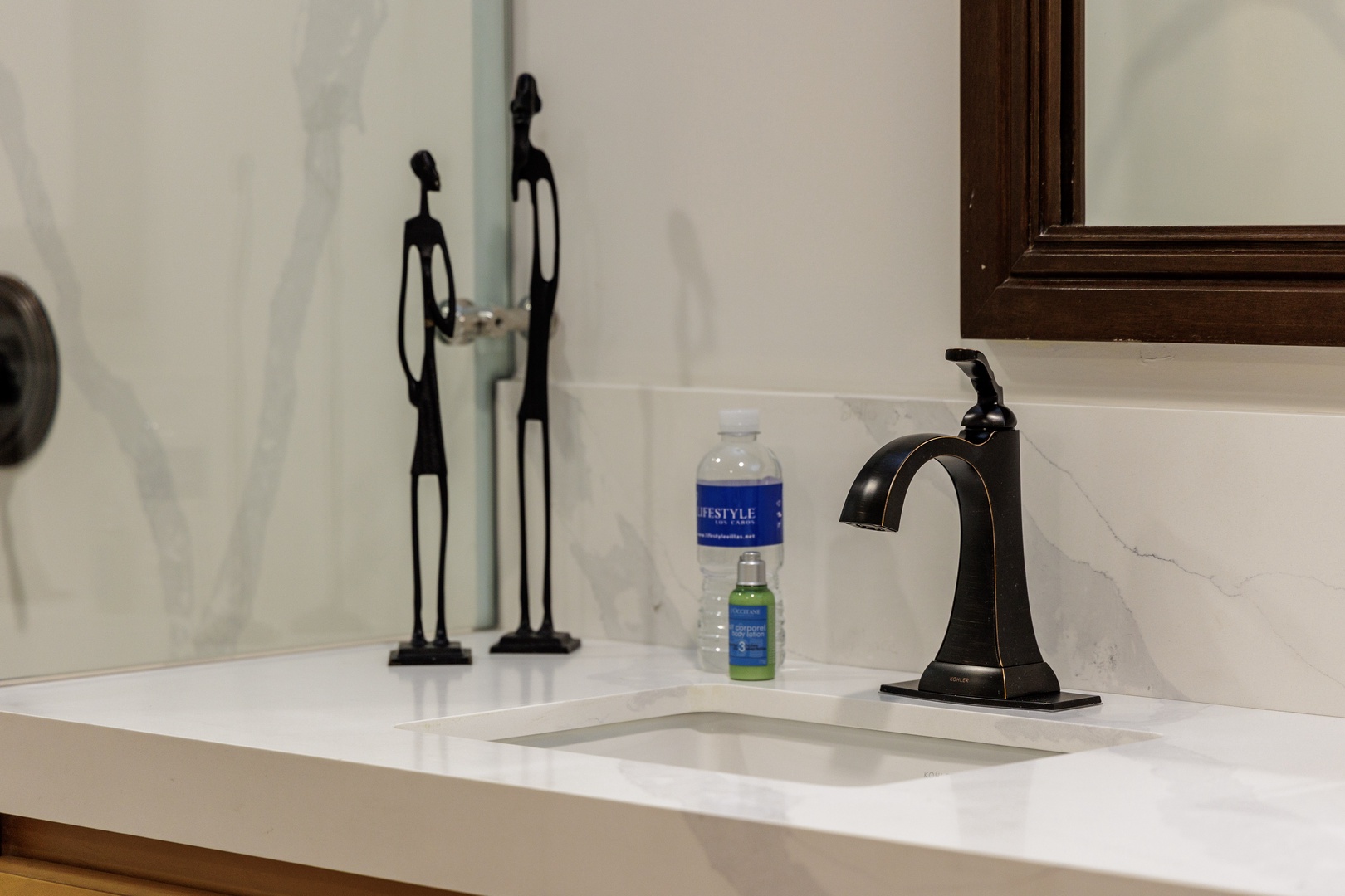 Your bathroom features elegant marble counters, a sleek modern faucet, and thoughtful decorative touches that create a refined, welcoming space.