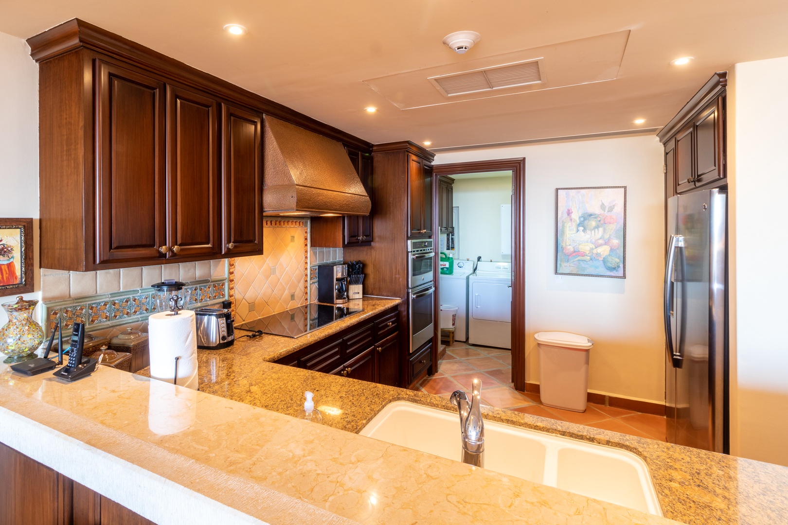 Your fully equipped gourmet kitchen features rich wood cabinetry, gleaming granite countertops, and stainless steel appliances—perfect for preparing memorable vacation meals together.