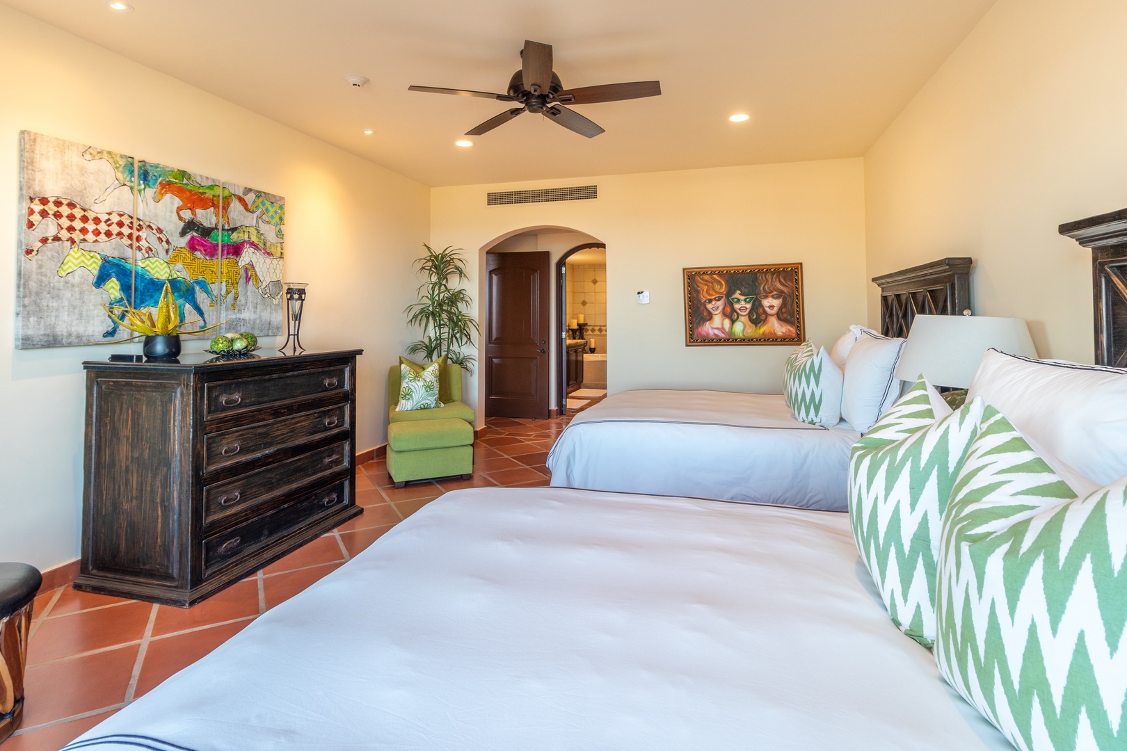 Unwind in your spacious bedroom where vibrant artwork and soothing green accents create a peaceful retreat. Two plush beds promise restful sleep after days of adventure.