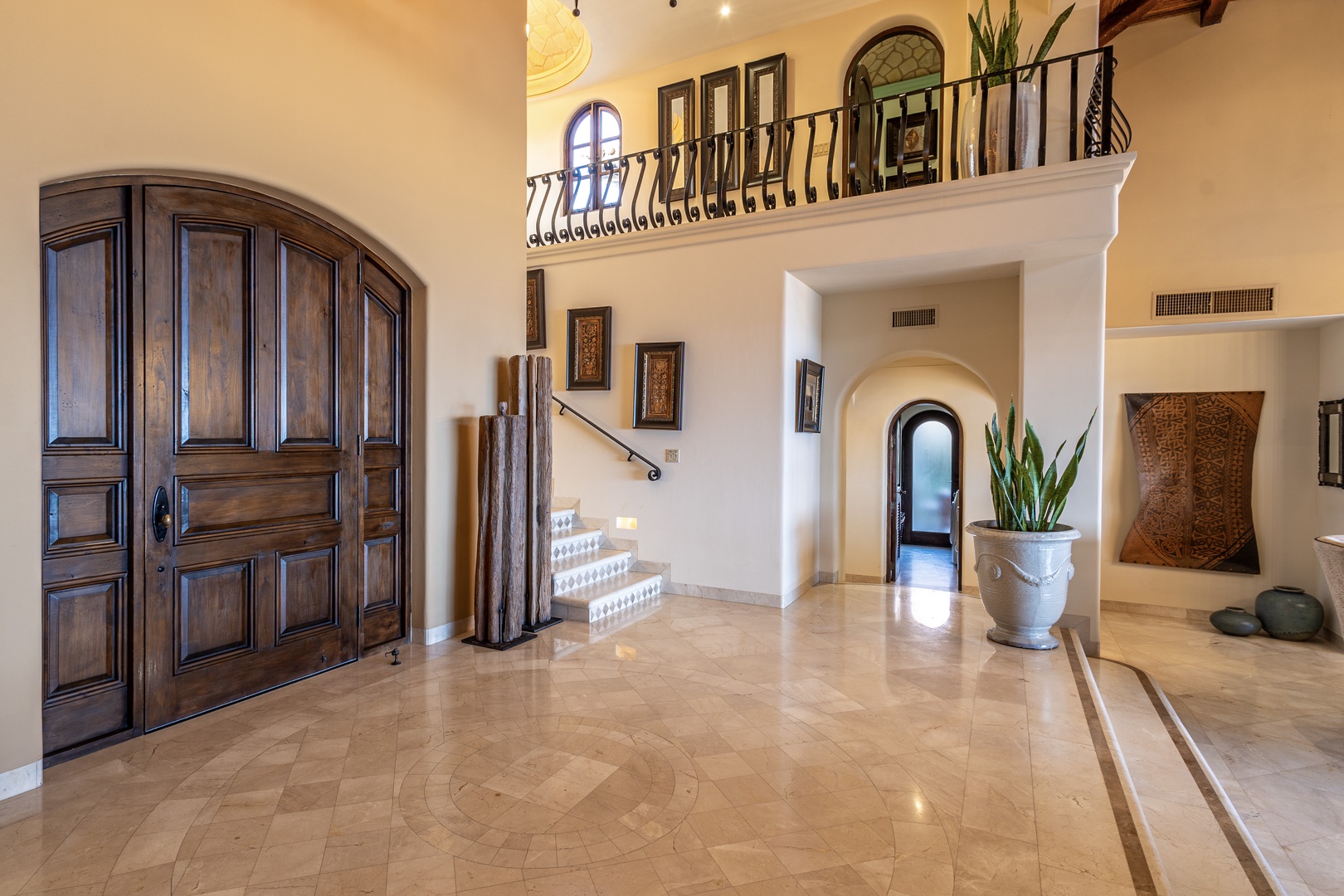 Step into your grand entrance hall where soaring ceilings and elegant arches welcome you home. Warm Mediterranean details and gleaming tile floors create an inviting first impression.