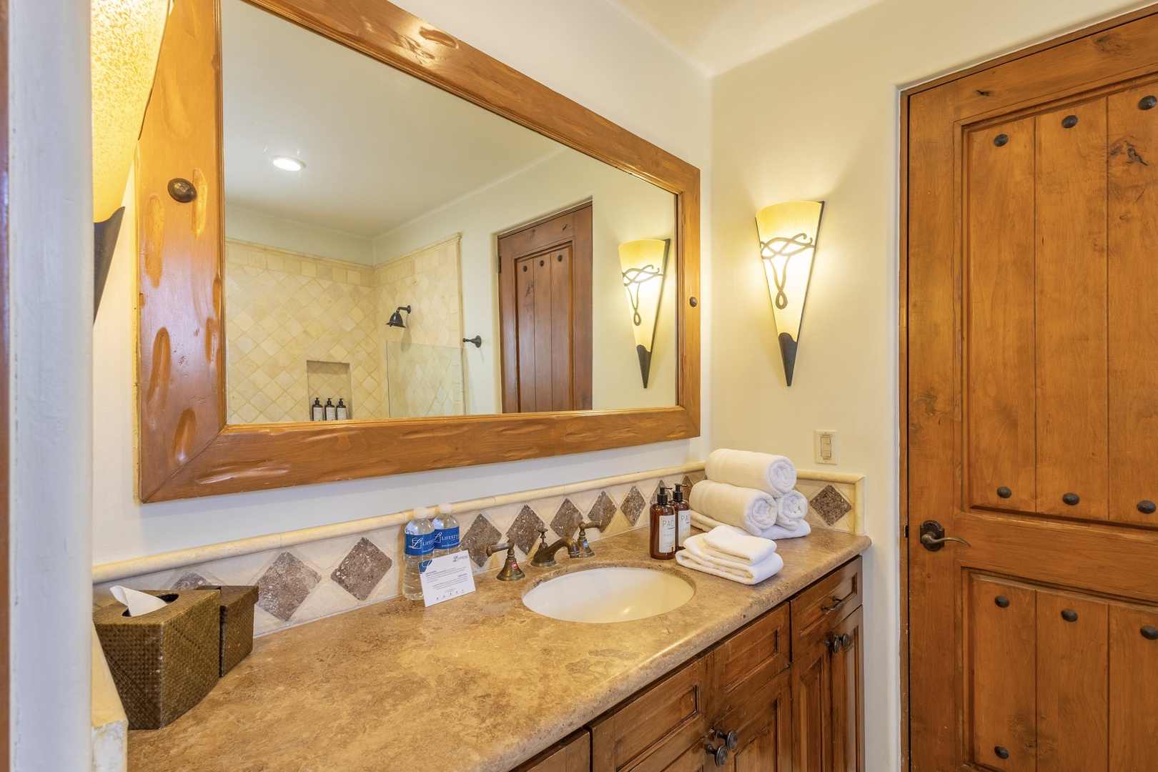 Indulge in your beautifully appointed bathroom featuring rich wood cabinetry, elegant stone countertops, and thoughtful amenities.