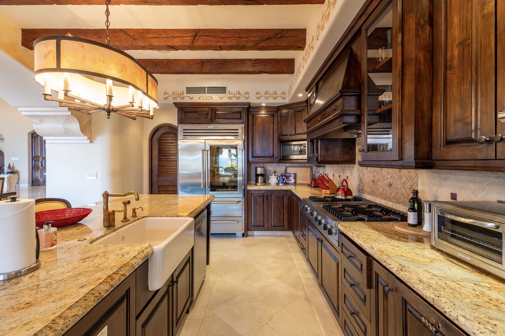 Your gourmet kitchen welcomes you with rich wood cabinetry, granite countertops, professional-grade appliances, and charming rustic beams overhead—a perfect space to create memorable meals together.