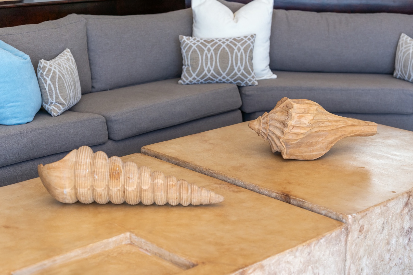Sink into plush sectional seating where decorative shells and thoughtful design create your perfect coastal retreat atmosphere.