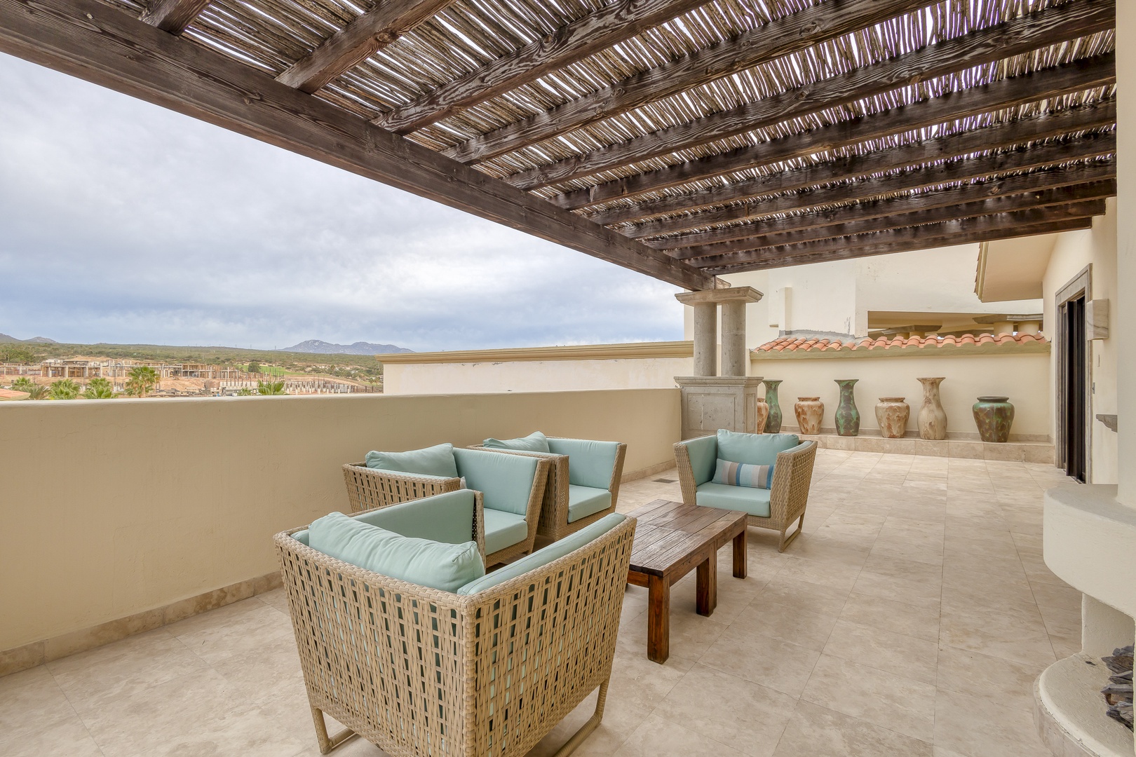 Spacious covered terrace with comfortable seating invites you to unwind while taking in the distant mountain views and desert landscape beyond.