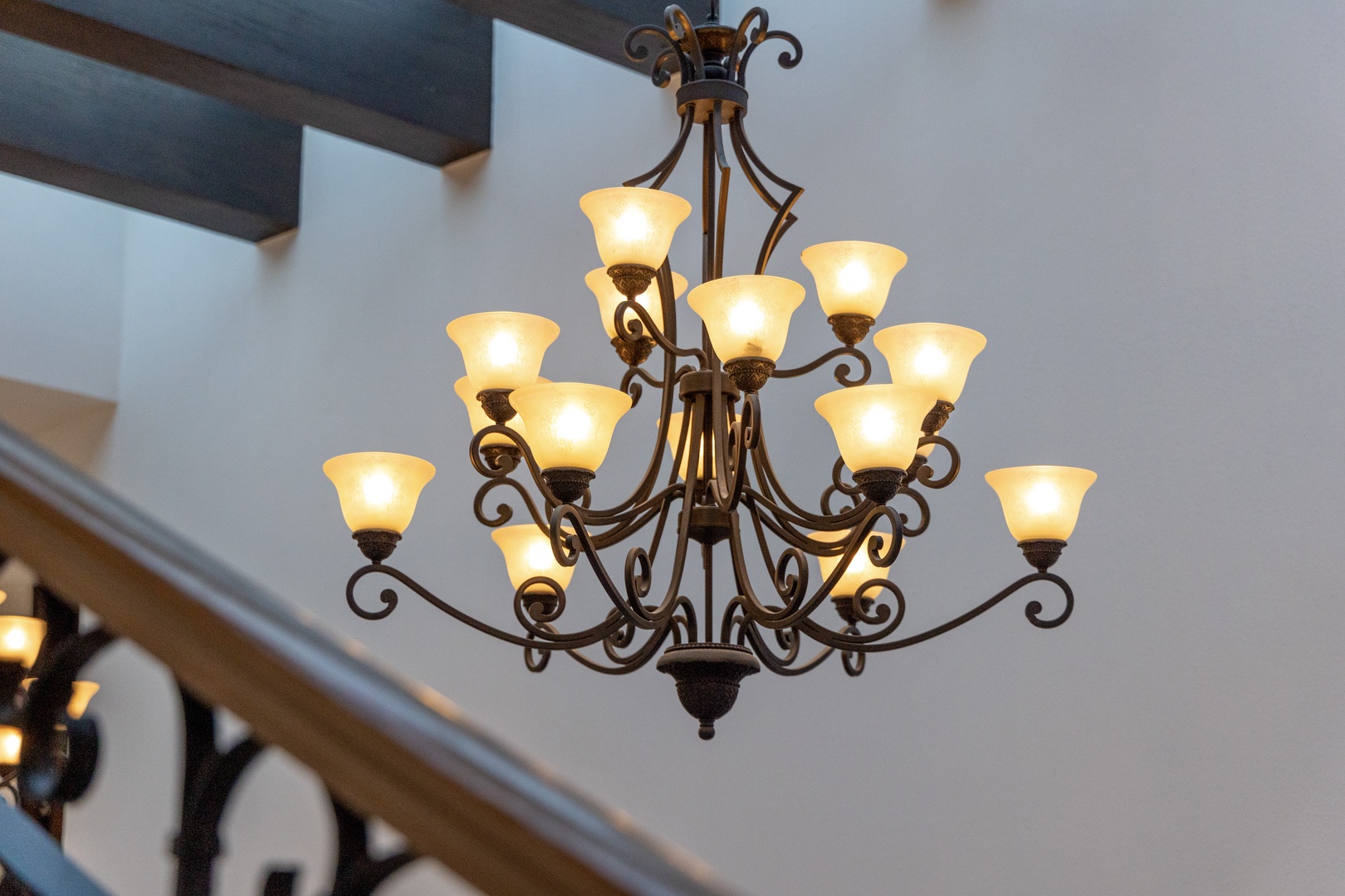 An elegant wrought-iron chandelier illuminates the entryway, casting a warm glow that welcomes you home after your daily adventures.