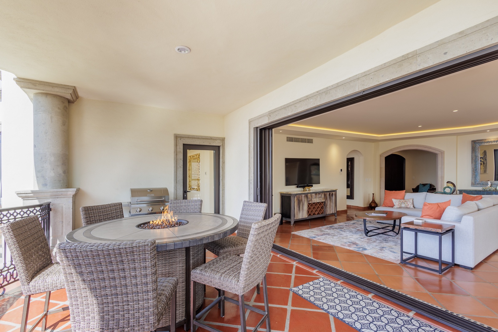 Gather around the fire pit at your private outdoor dining space, where terracotta tiles and elegant columns frame seamless indoor-outdoor living perfect for warm evenings.
