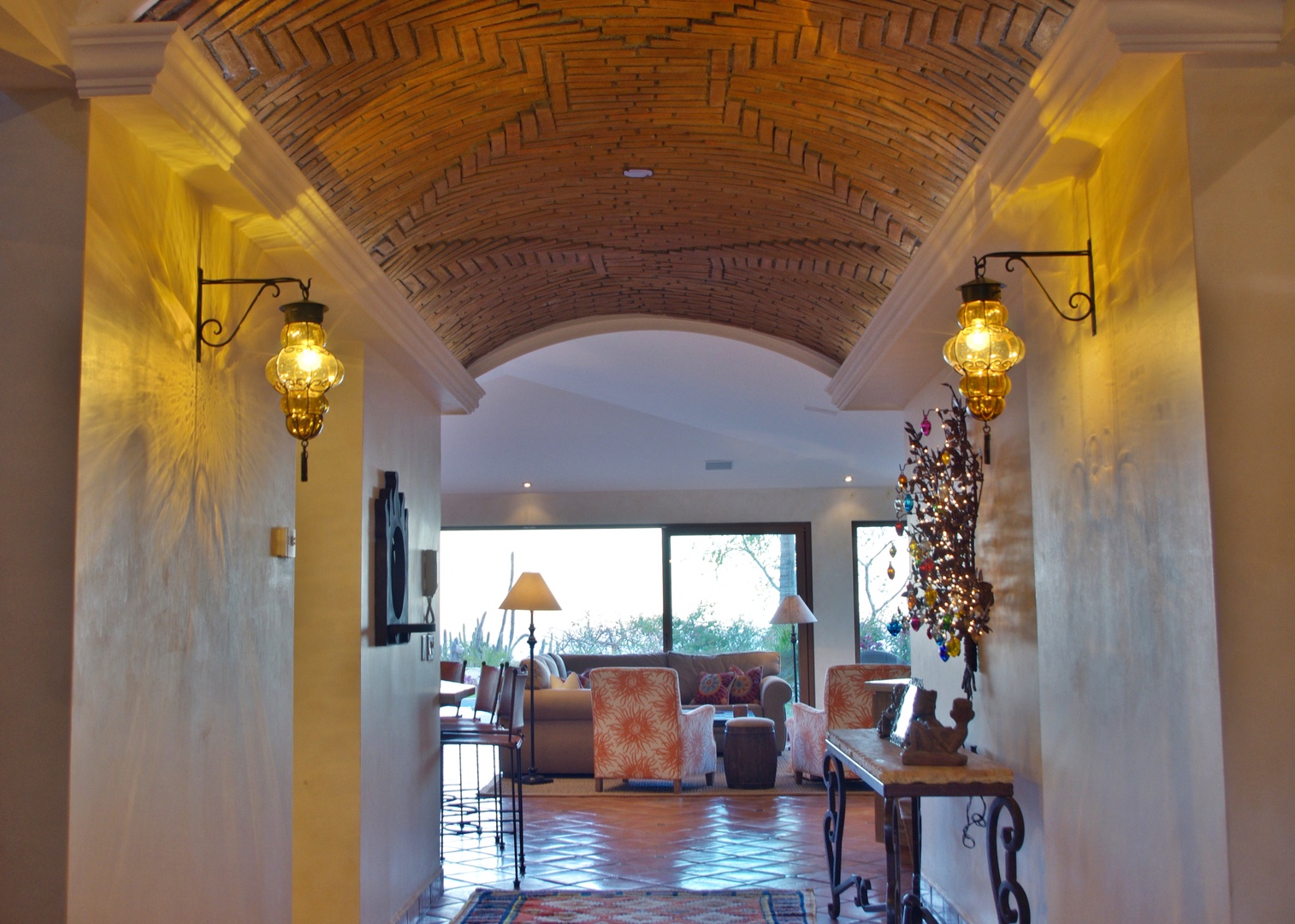 Step through this stunning barrel-vaulted brick archway into a warm, artfully lit lounge where rustic elegance meets modern comfort and peaceful views.