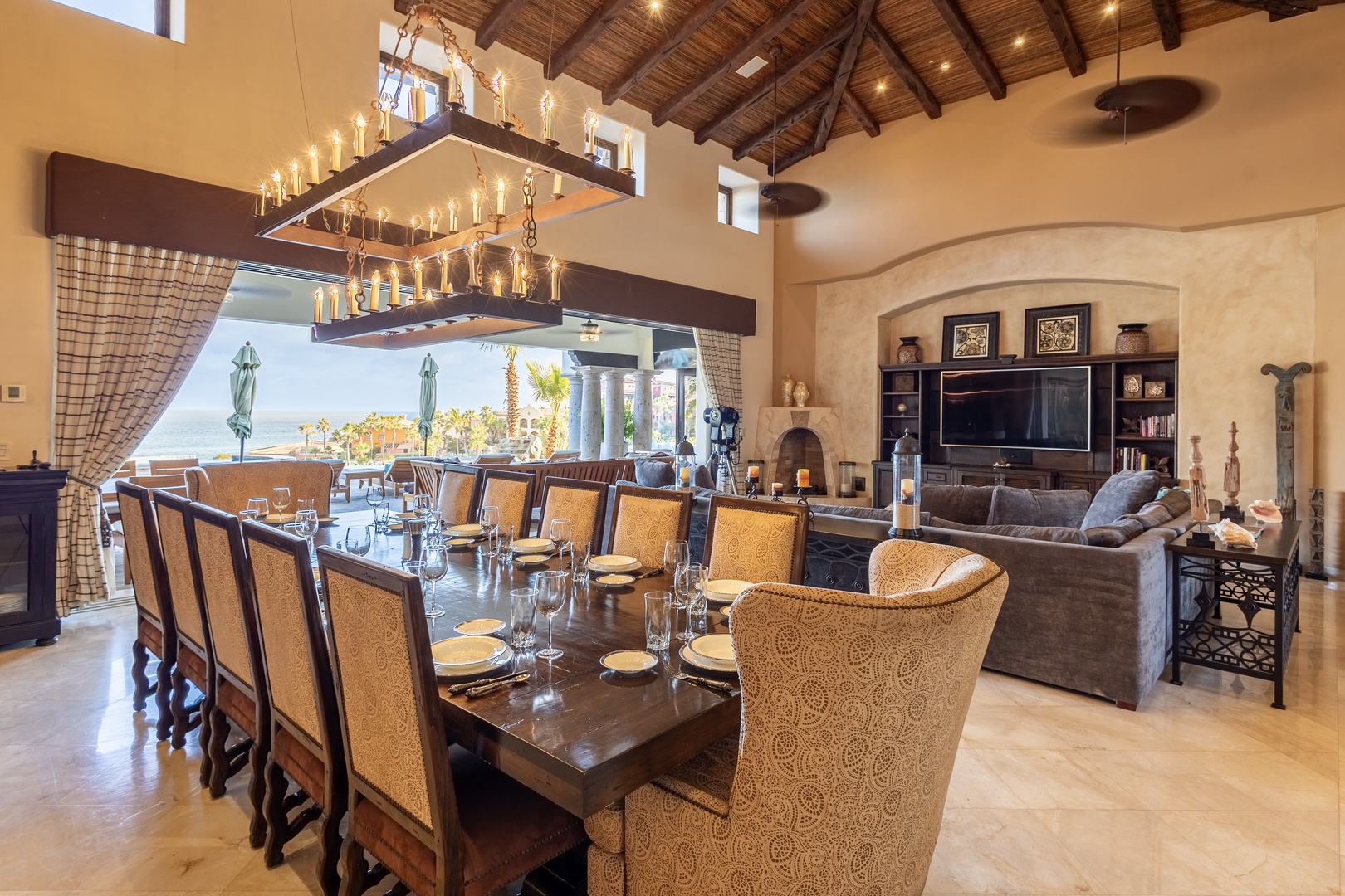 Step into your spacious, light-filled haven where elegant dining meets relaxed coastal living. Soaring wood-beam ceilings, a grand chandelier, and open views create an inviting atmosphere perfect for gathering and unwinding.