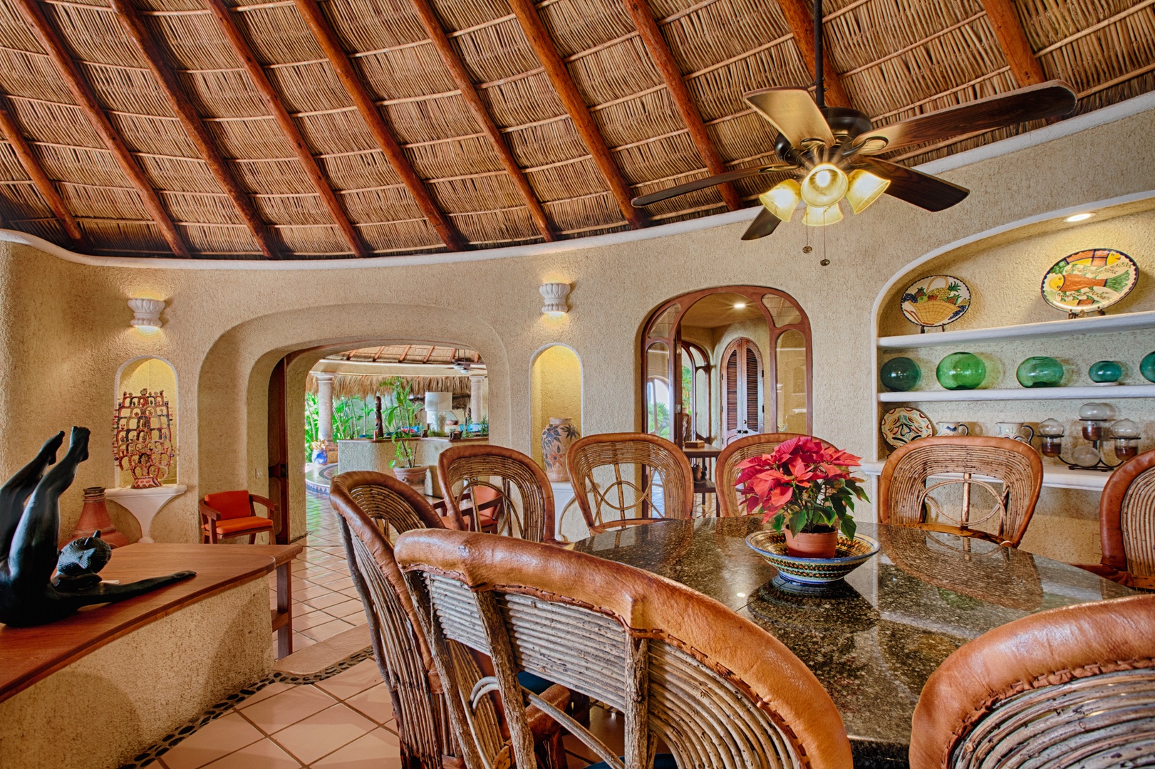 Gather around your stunning dining table beneath the traditional palapa roof, where warm lighting and tropical breezes create unforgettable meal experiences.