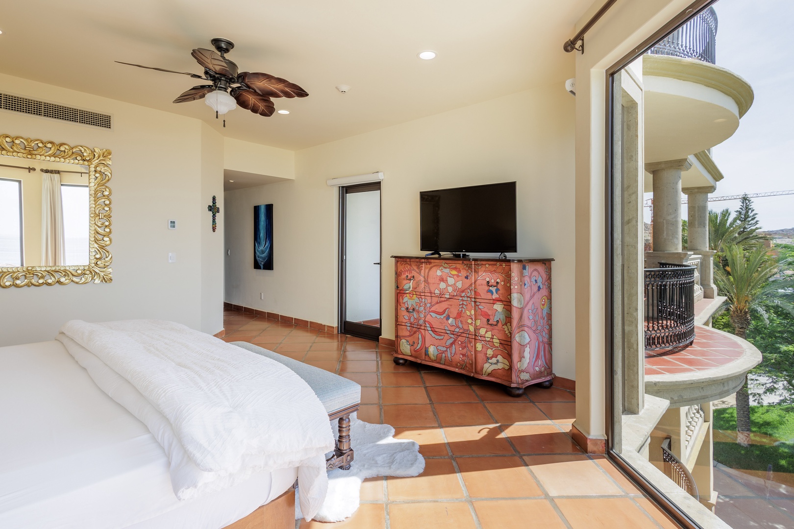 Wake up in this bright bedroom where tropical breezes from your private balcony meet relaxed elegance. Terracotta floors, a handcrafted cabinet, and lush garden views create your peaceful retreat.