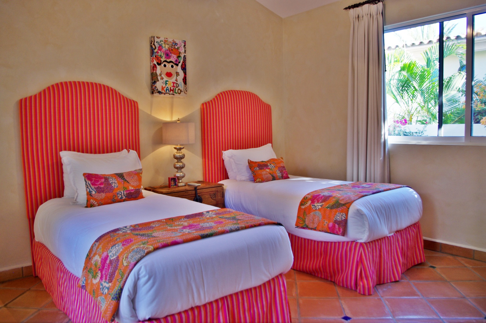 Sink into crisp linens and vibrant pops of color in this cheerful twin bedroom. Natural light and garden views create your perfect retreat for relaxation.