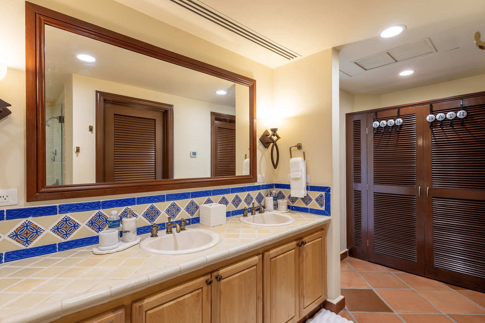 Admire the handcrafted tile backsplash and dual vanity in your spacious bathroom, complete with rich wood cabinetry and ample storage.