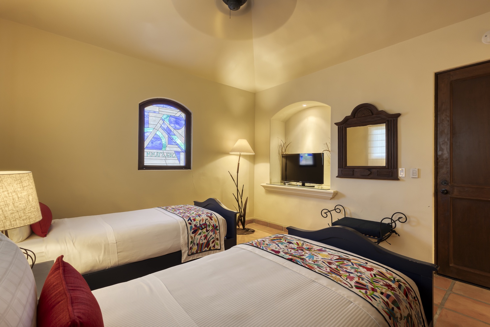 Rest peacefully in your charming twin bedroom with colorful textiles, warm lighting, and thoughtful amenities for a comfortable stay.