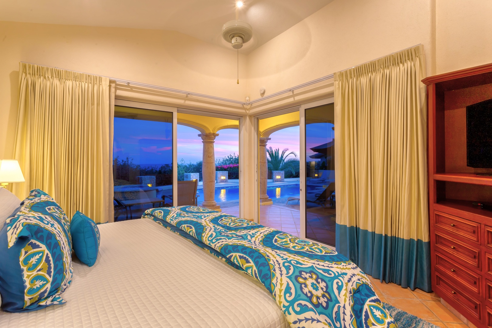 Wake up to stunning twilight views through your corner windows, where elegant bedding meets tropical paradise beyond your private terrace.