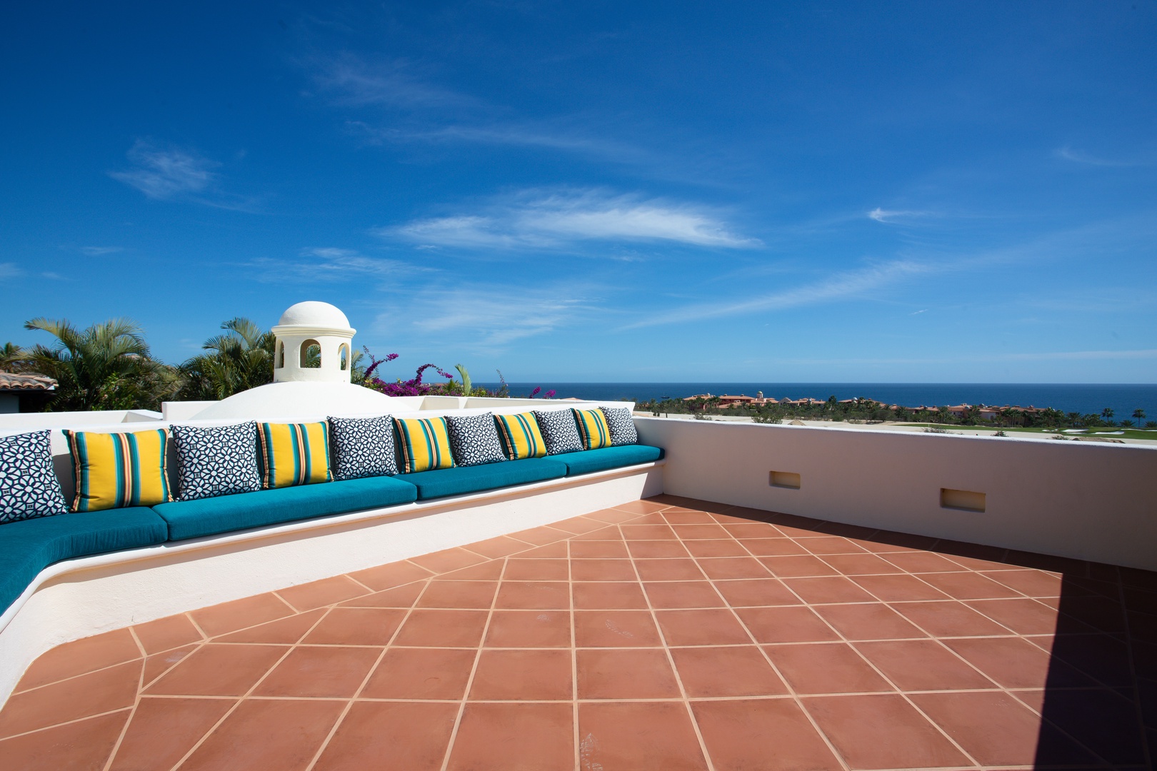 Stretch out on vibrant cushions while taking in sweeping ocean views from your private rooftop terrace.