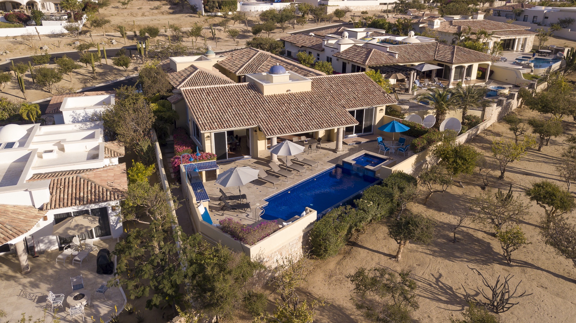 Stunning aerial view of a luxurious desert villa featuring a private pool and outdoor living spaces in an exclusive residential neighborhood.