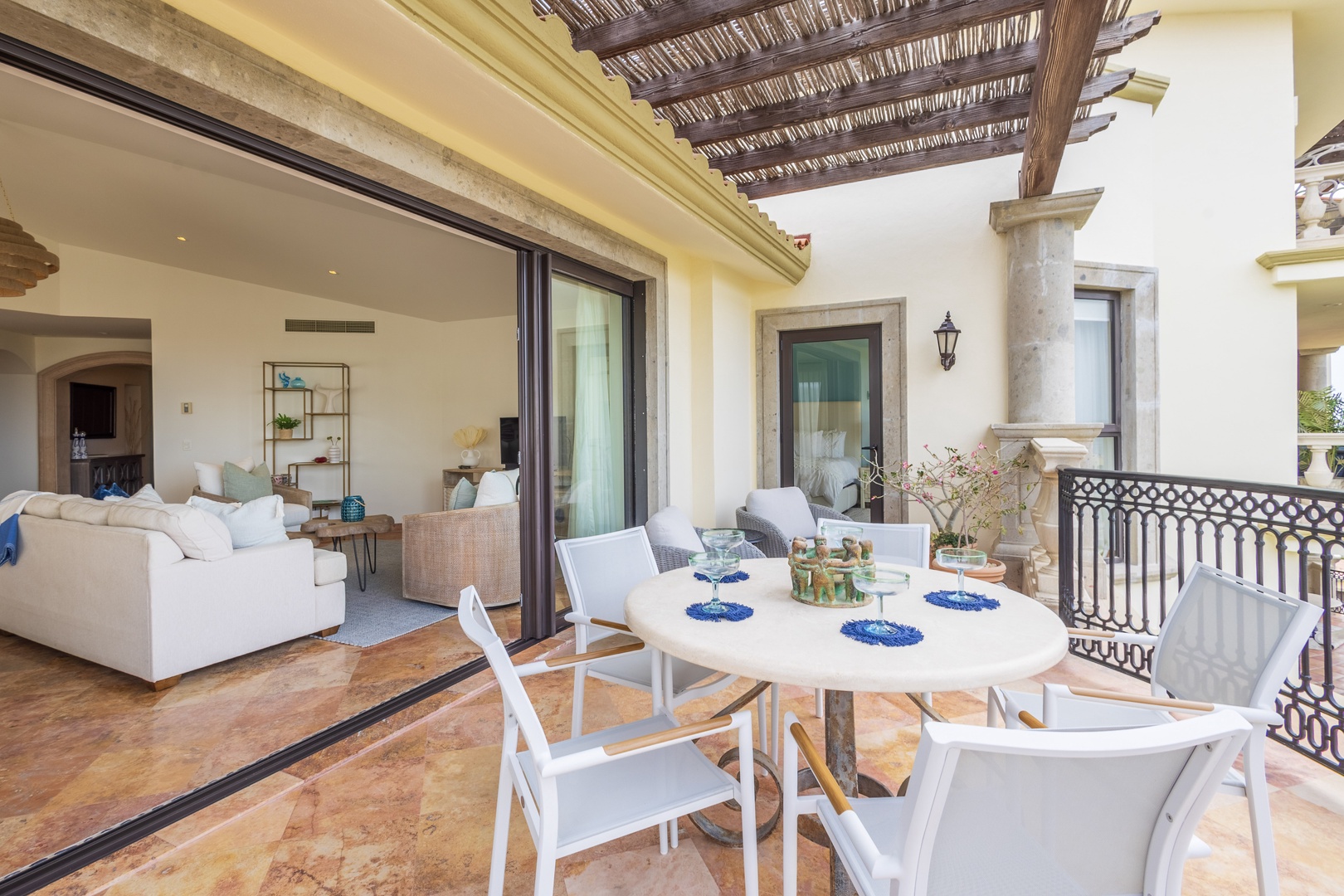 Your private terrace seamlessly blends indoor-outdoor living with elegant dining space and plush lounge seating under rustic pergola beams.