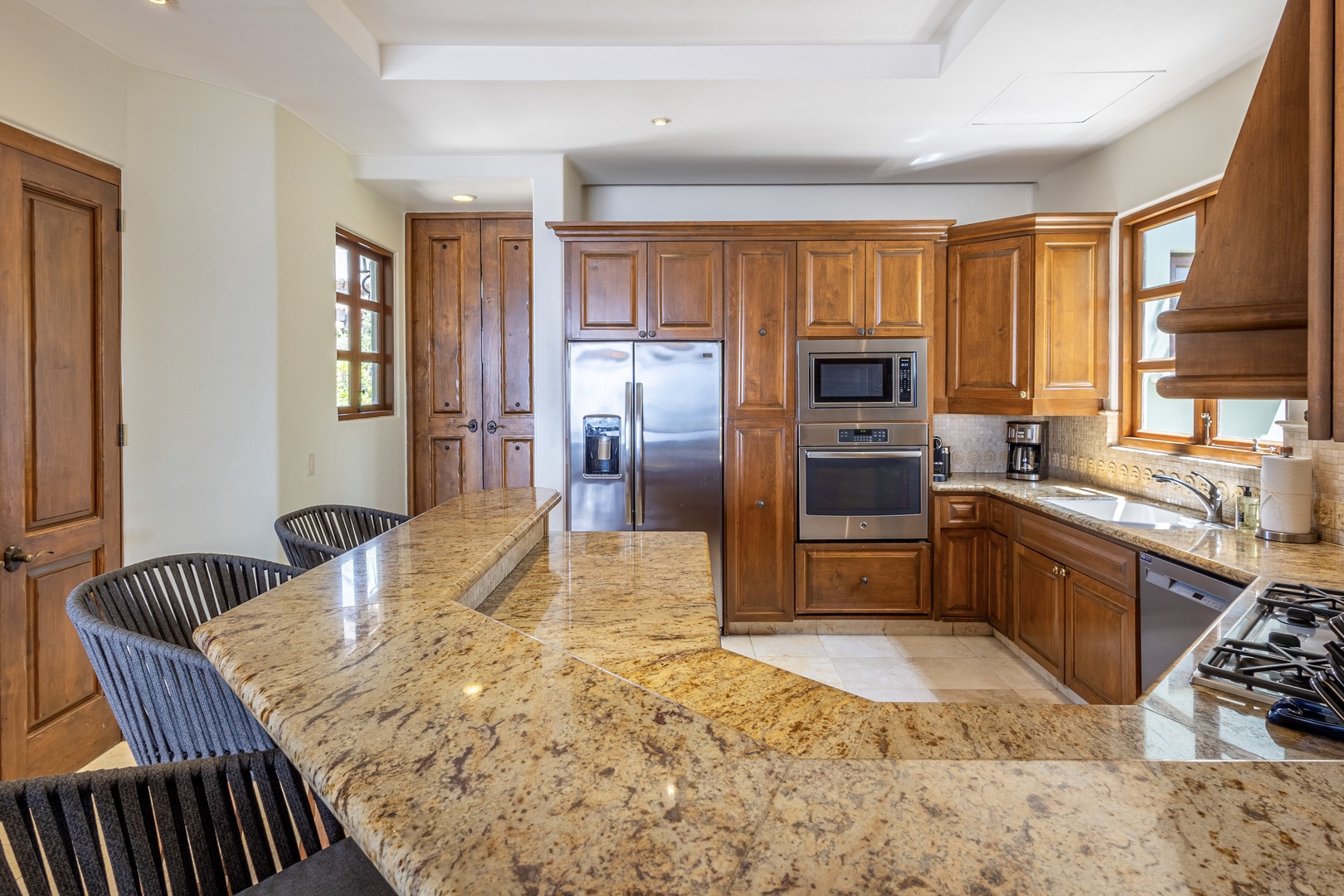 Prepare your favorite meals in this stunning gourmet kitchen, where gleaming granite countertops and rich wood cabinetry create the perfect culinary retreat for your vacation.