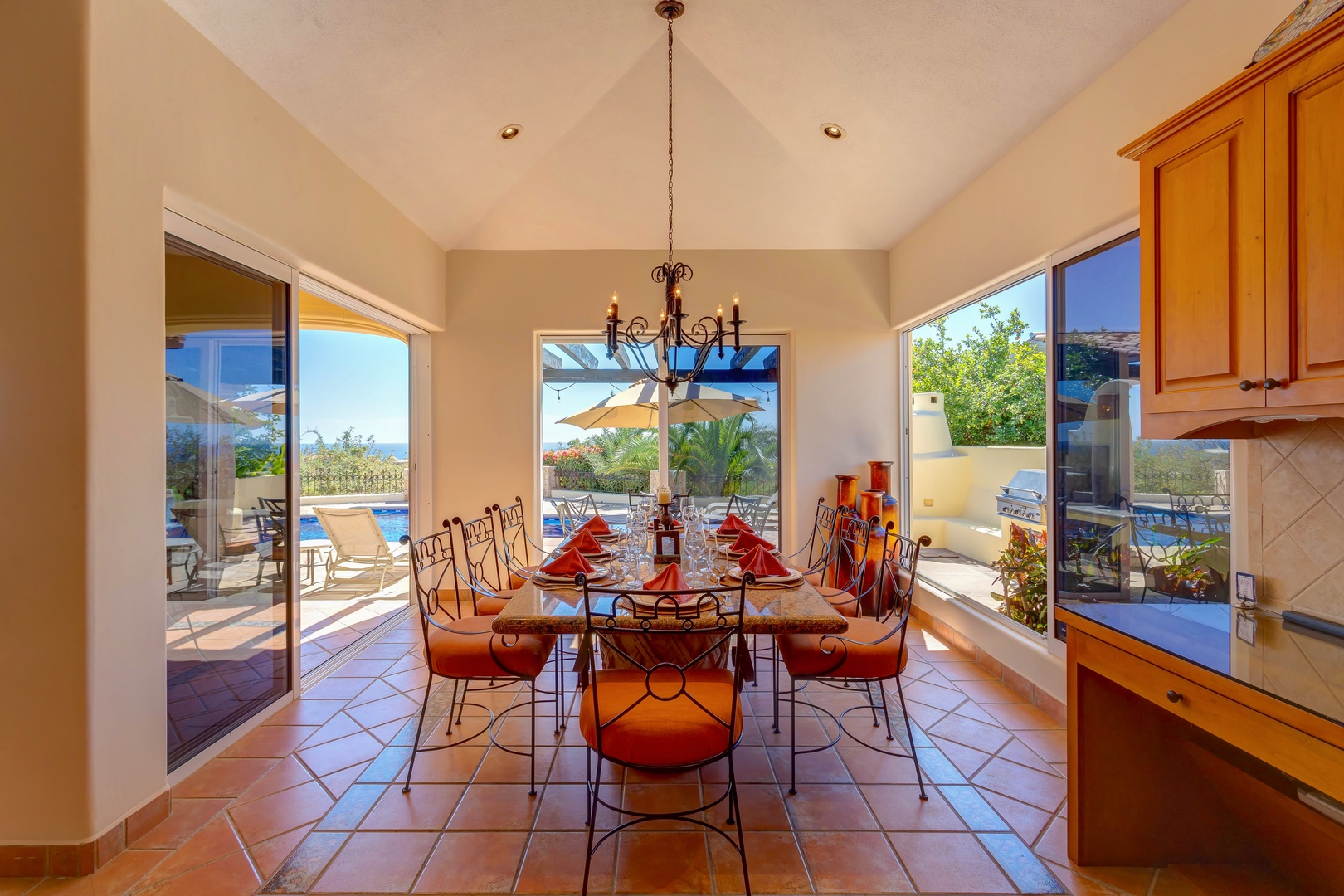 Your spacious dining room opens to stunning pool views through floor-to-ceiling windows, creating perfect indoor-outdoor flow for memorable meals.