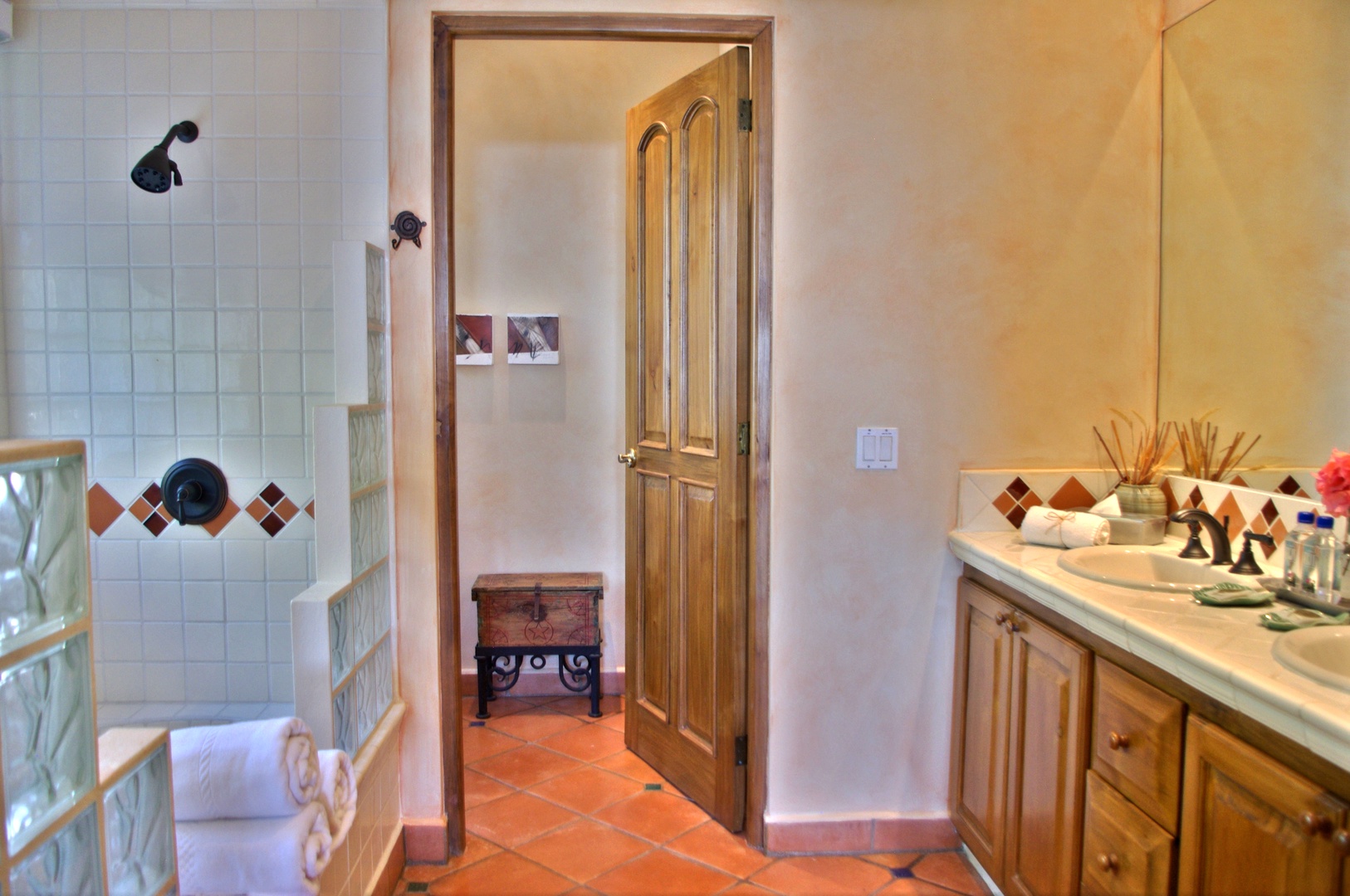 Step into your private bathroom with charming tile details, a refreshing walk-in shower, and thoughtful touches like fresh towels waiting for you.