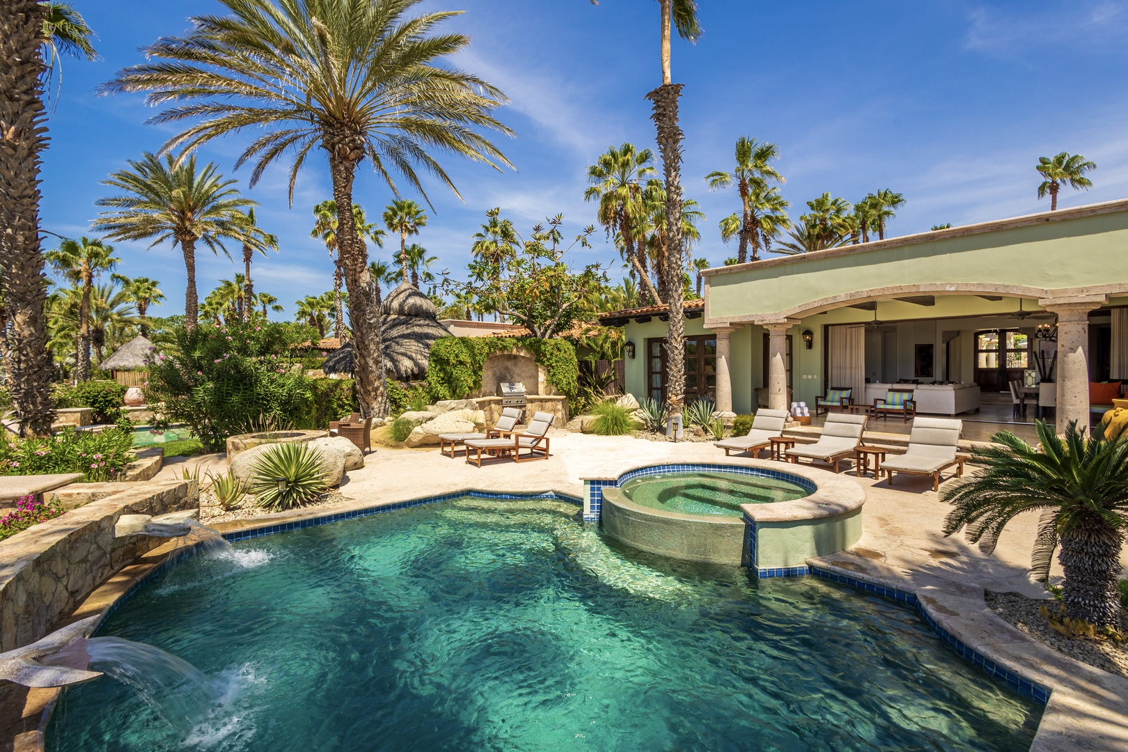 A sun-drenched private oasis surrounded by swaying palms and lush desert landscaping. Lounge by the sparkling pool, soak in the hot tub, or unwind on the terrace—your own slice of paradise awaits.