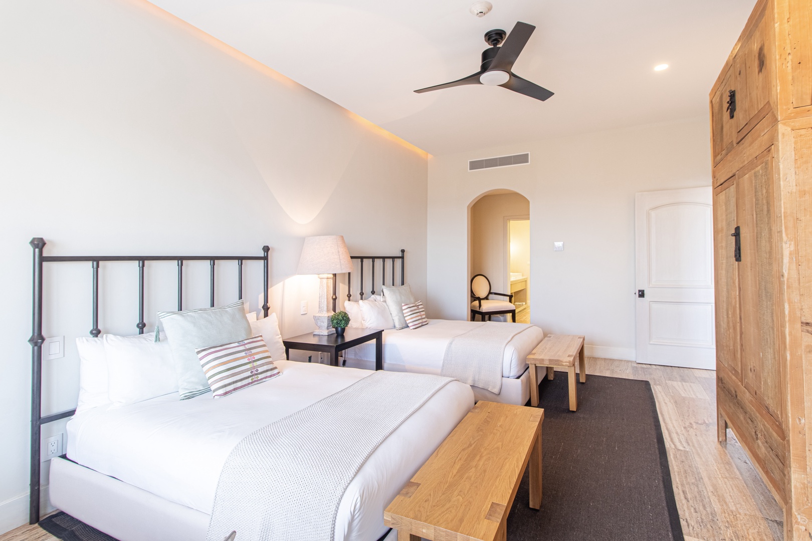 Bright, serene bedroom with fresh linens and subtle lighting creates your peaceful haven. The rustic wardrobe and contemporary touches blend comfort with style for a restful stay.