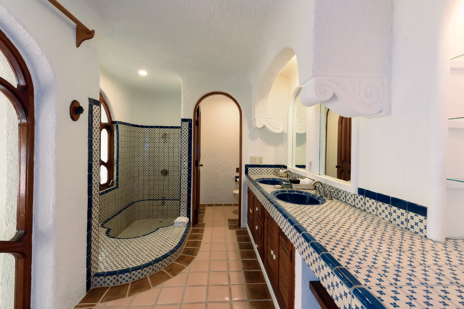 Your beautifully tiled bathroom features a spacious walk-in shower, dual vanities, and elegant mosaic details that bring warmth and character to your daily routine.